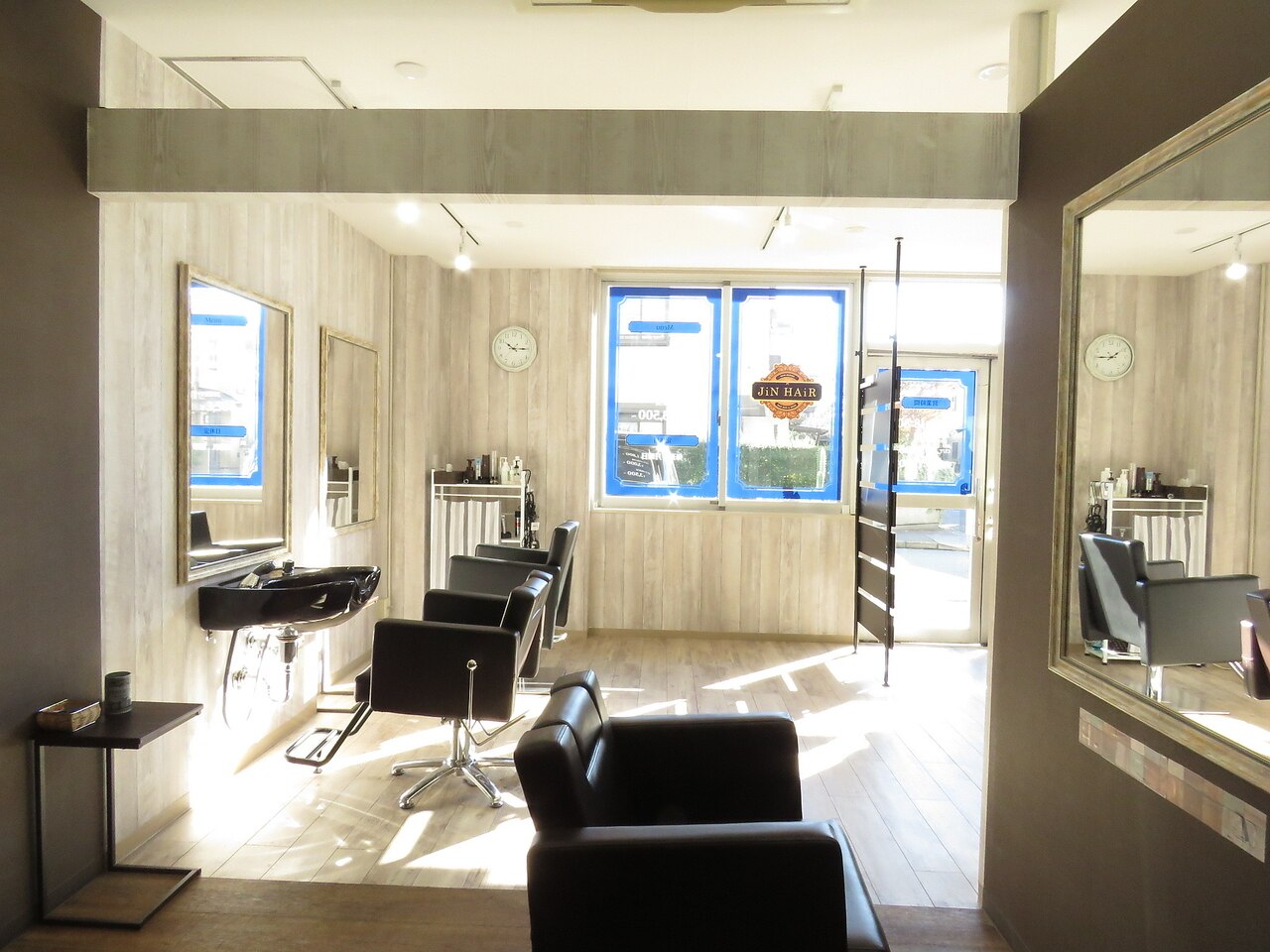 JiN HAiR の店内（落ち着いた木とコンクリートのインテリア）