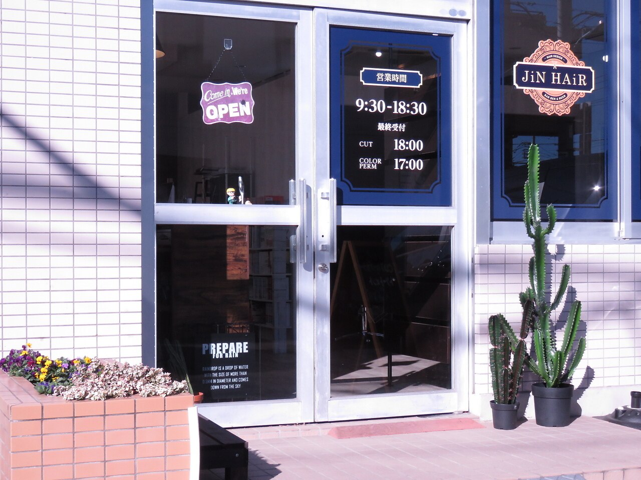 ジンヘアー(JiN HAiR)の外観・ガラス張りドアとサボテンのある店舗入口